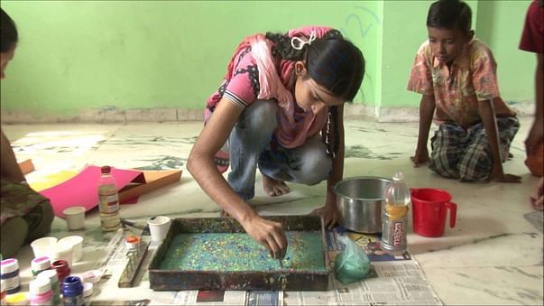 Neha a 9th grader doing marbling on bags for fund raising event.