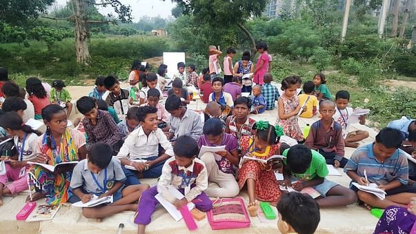 Children studying Roadside in open.