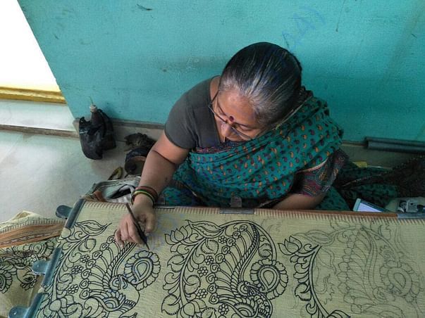 Village artisans hand painting kalamkari motifs