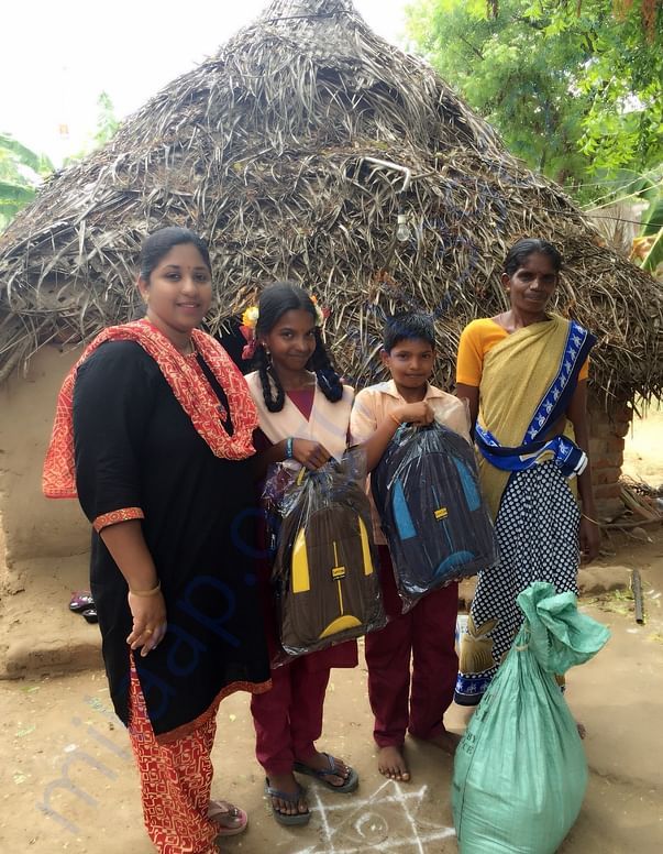 Indra with her children before her house