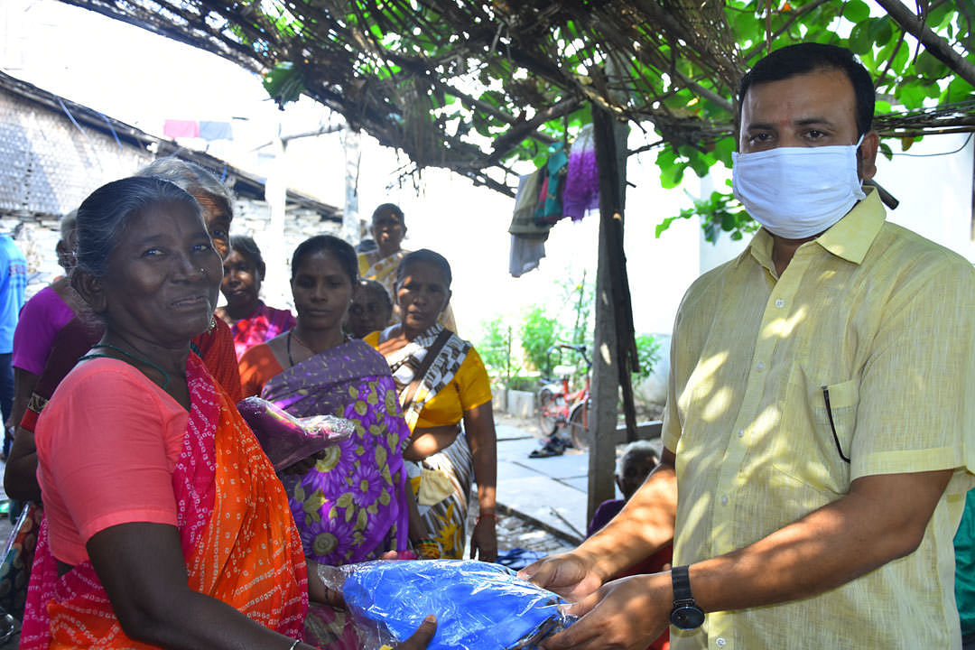 Poor Elderly person getting clothes donation from best charity india